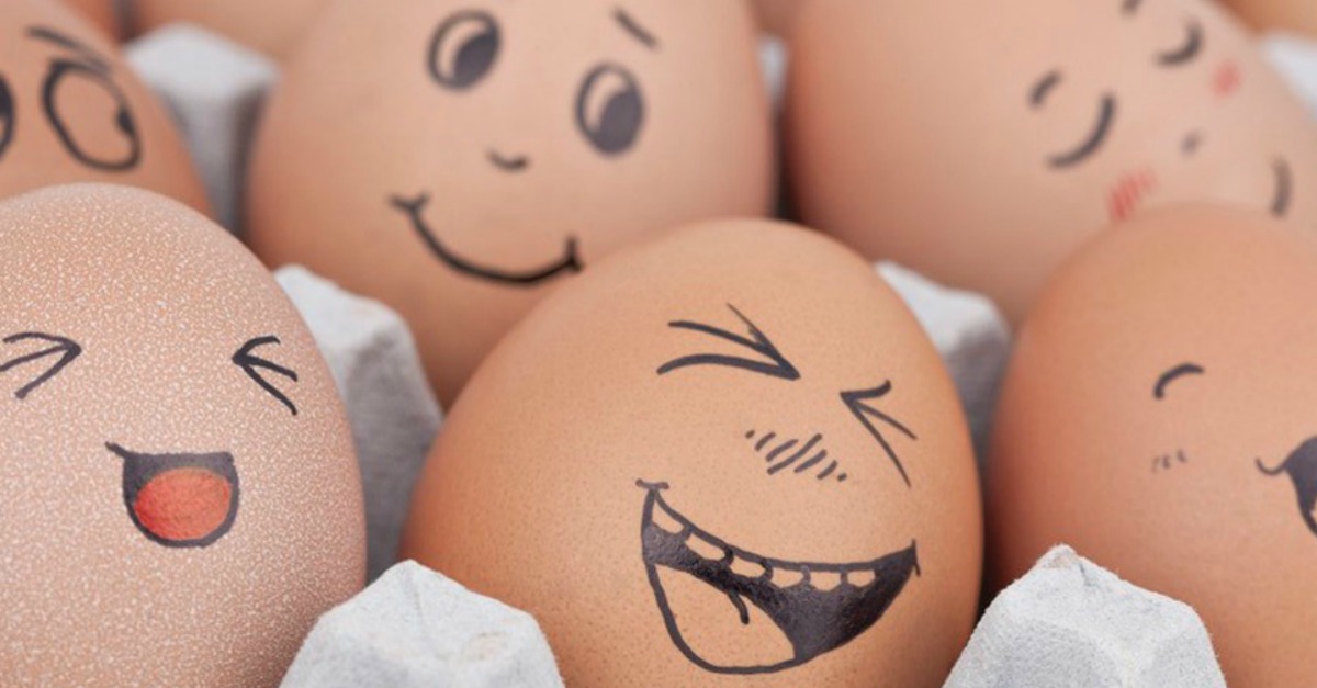 A carton of eggs with laughing faces drawn on them. They must be cracking up at our egg-septional egg puns too. (Image via Aaron Woodward Graphics)