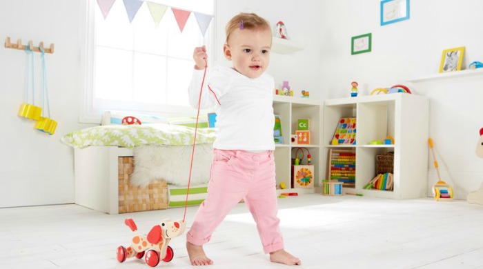 Product testers wanted: A baby playing with a Hape Walk-A-Long Dog toy.