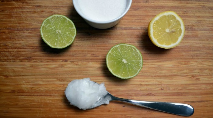 Sliced lemon and lime and a spoonful of coconut oil.