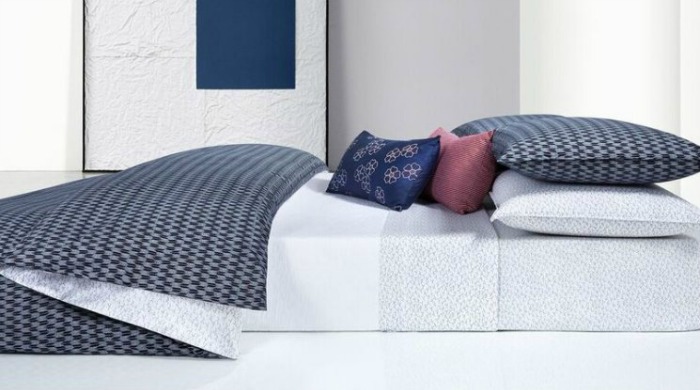 A bed made up with Calvin Klein Aurora Indigo bed linen.