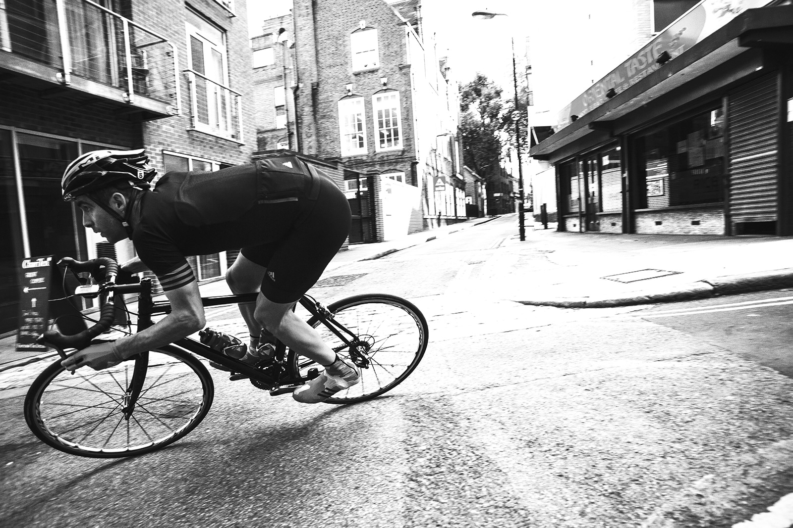 Cyclist riding round a bend wearing adidas cycling gear