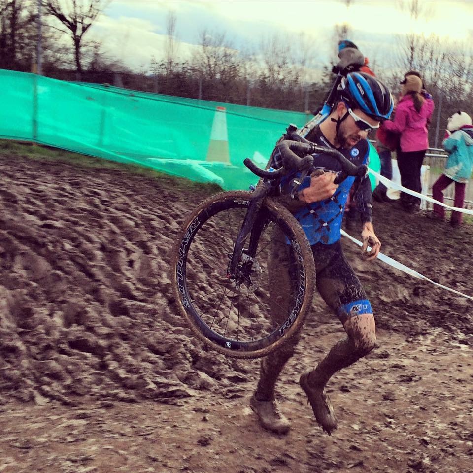 Cyclist carrying his bike in a cyclo-cross race