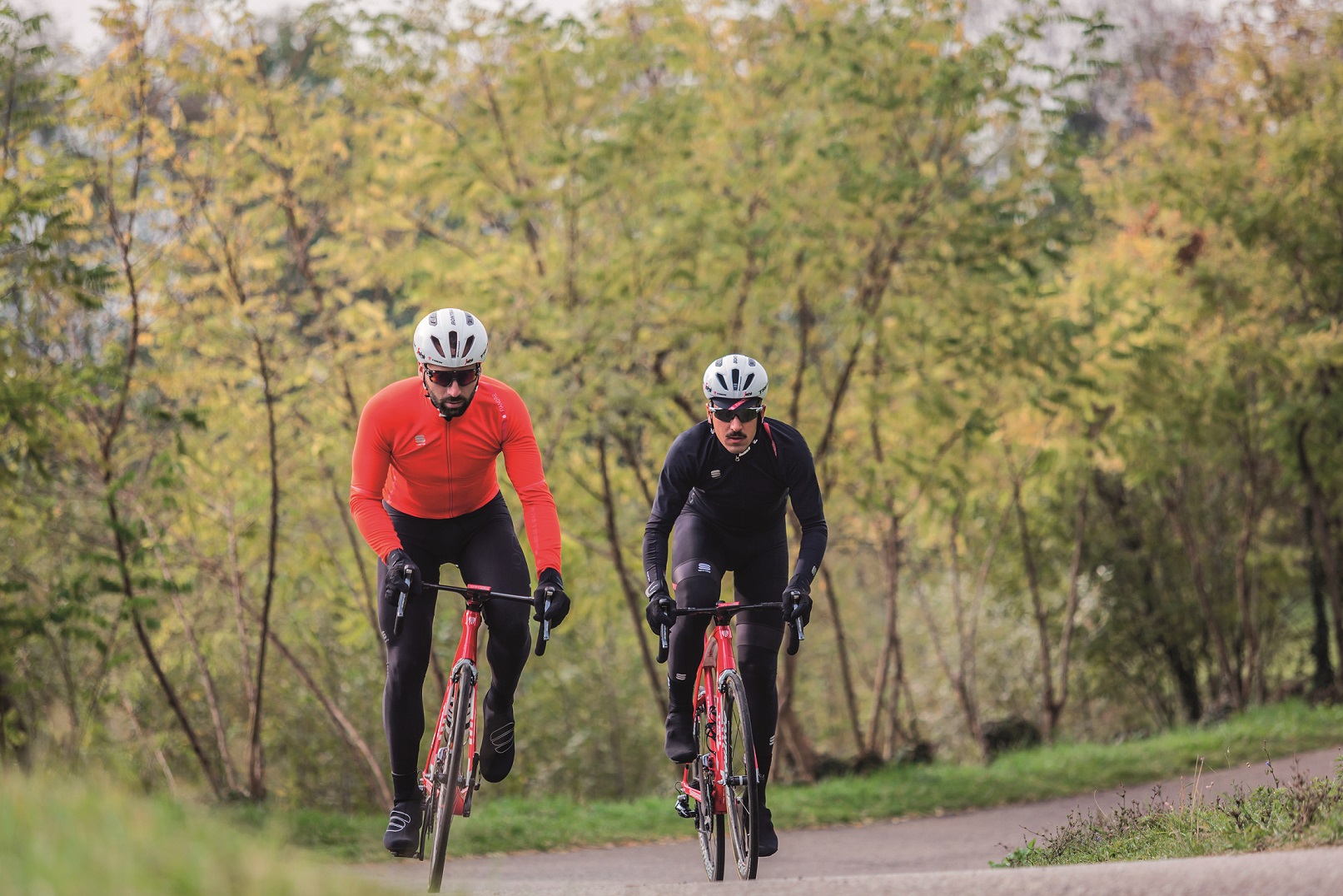 two cyclists riding their road bikes in winter