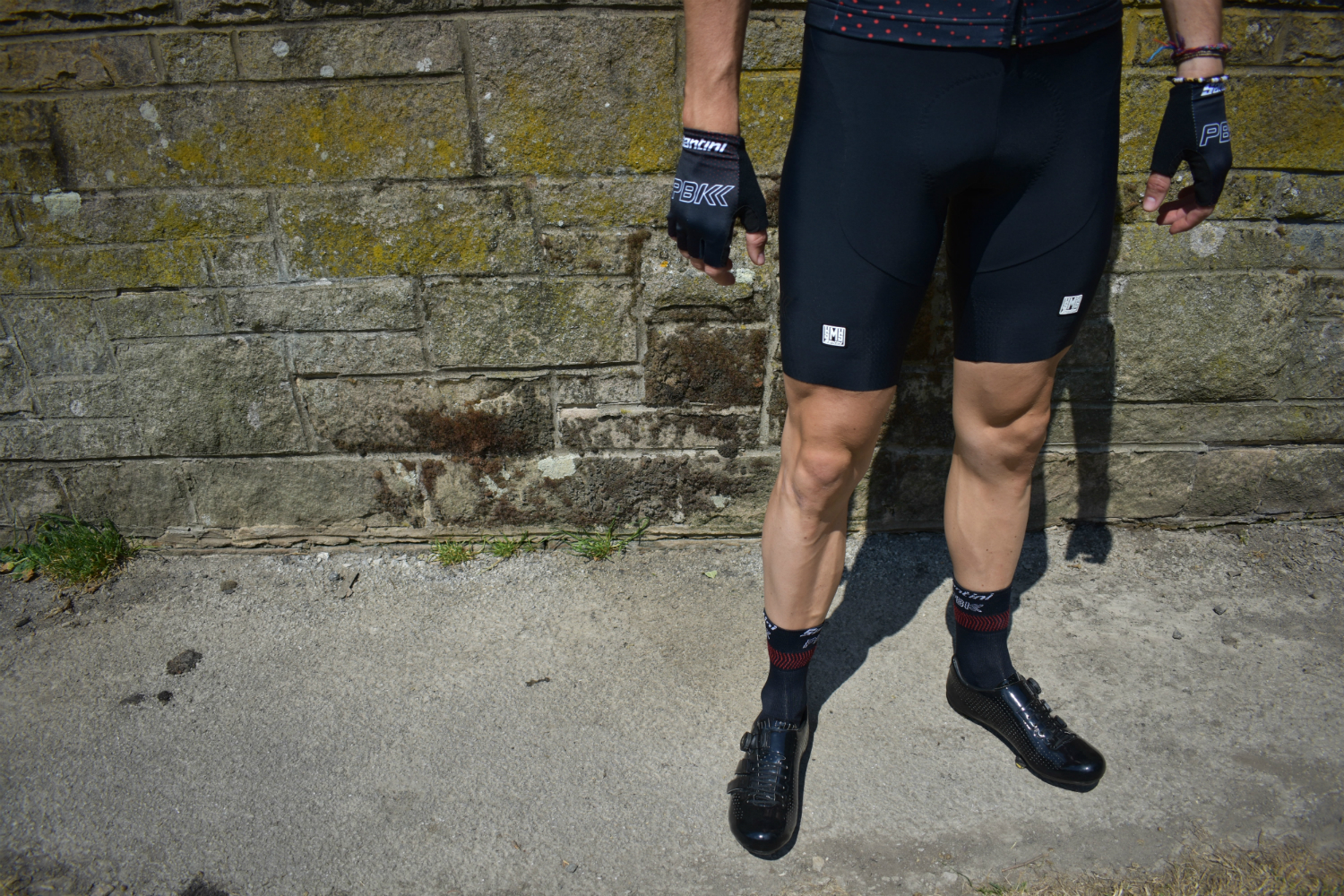 a cyclist standing in the pbk santini bib-shorts, socks and gloves