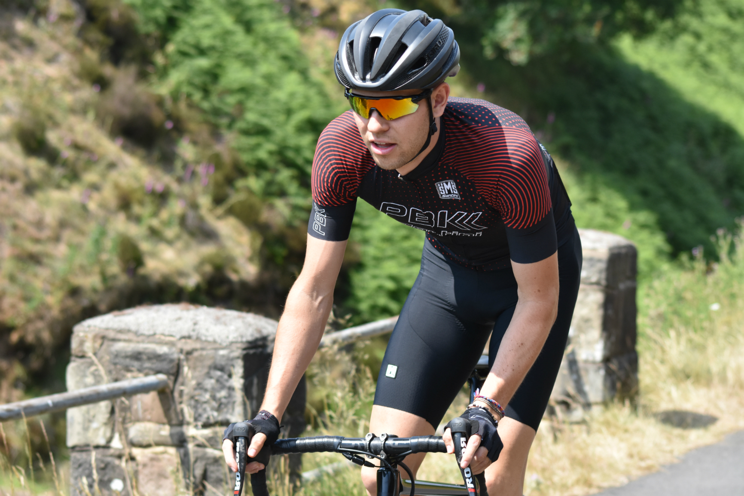 a cycling riding uphill on the huds in the pbk santini clothing collection