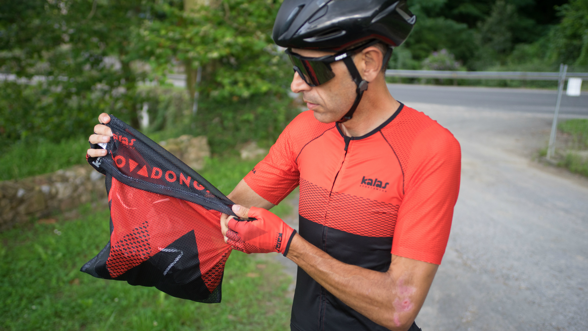 a cyclist holding the kalas covadonga jersey