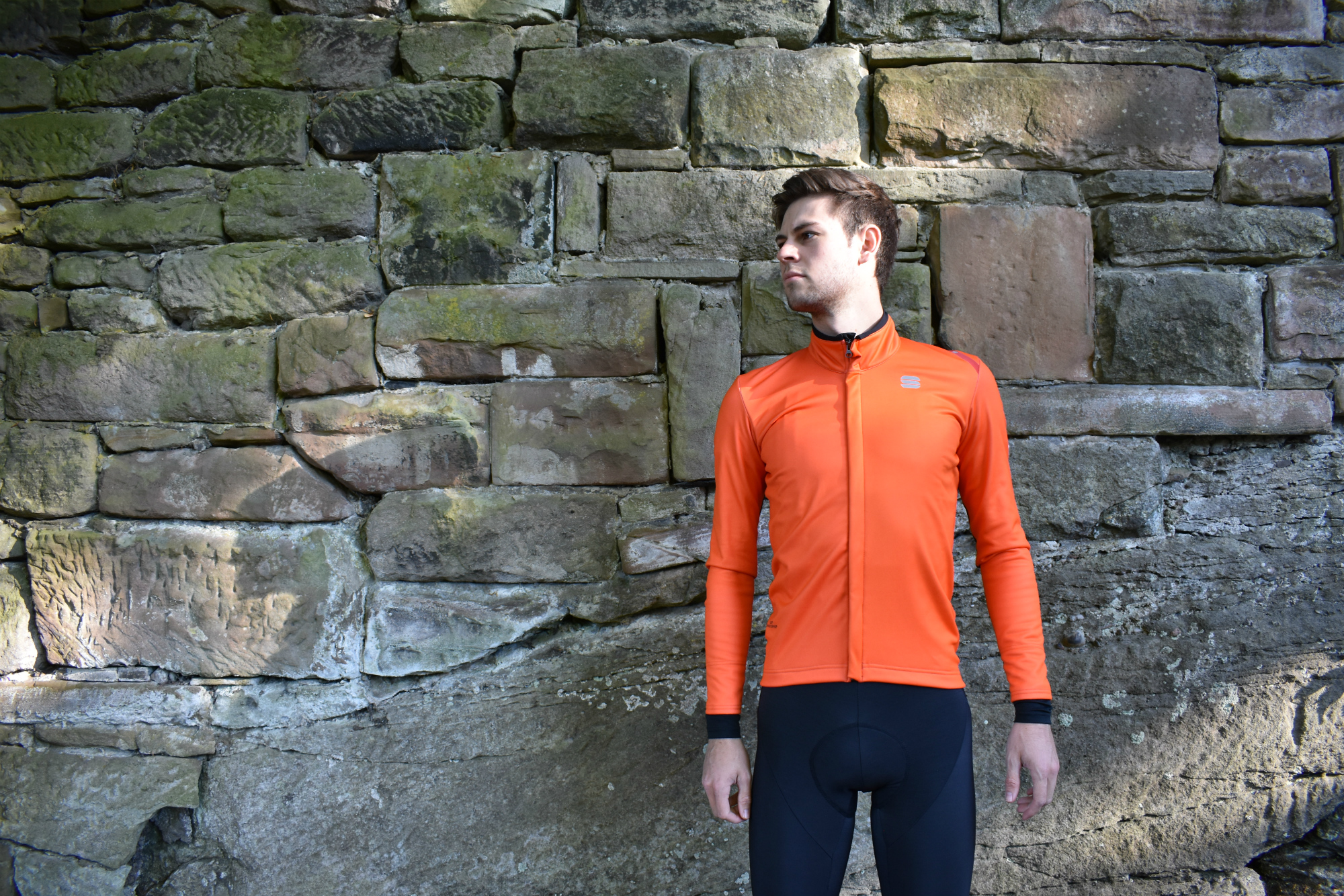 a cyclist standing next to a wall in the fiandre cabrio jersey