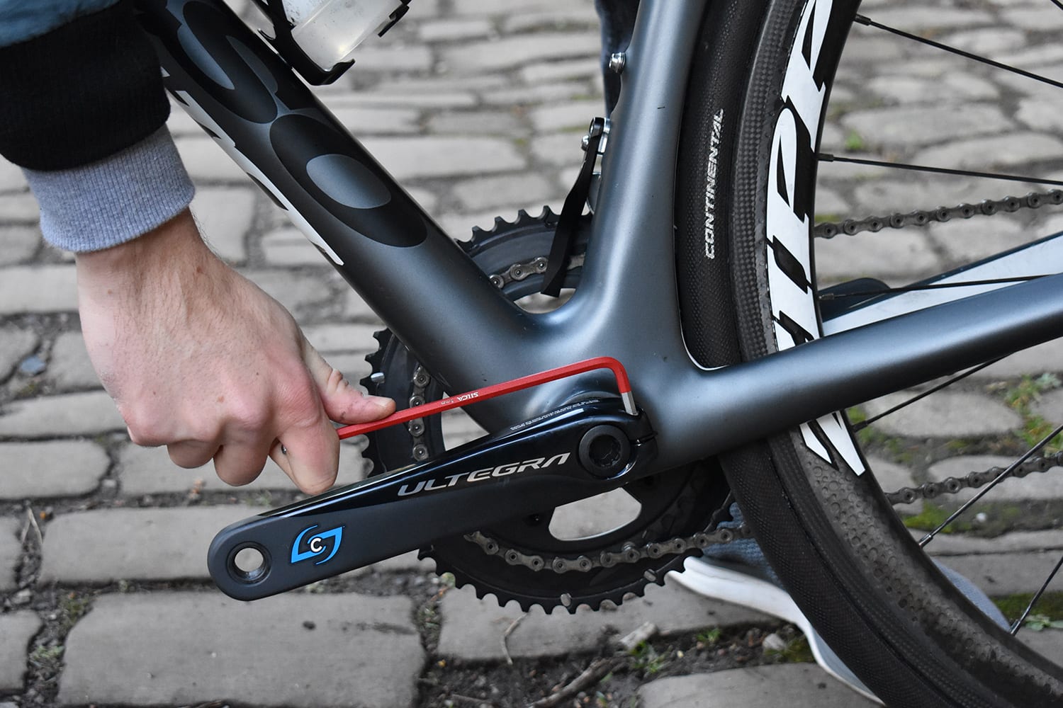 a cyclist working on a bike with a 5mm silca hx two allen key