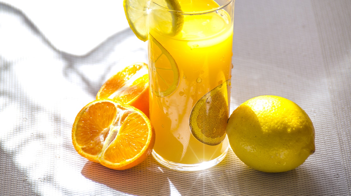 glass of orange juice and cut citrus fruits