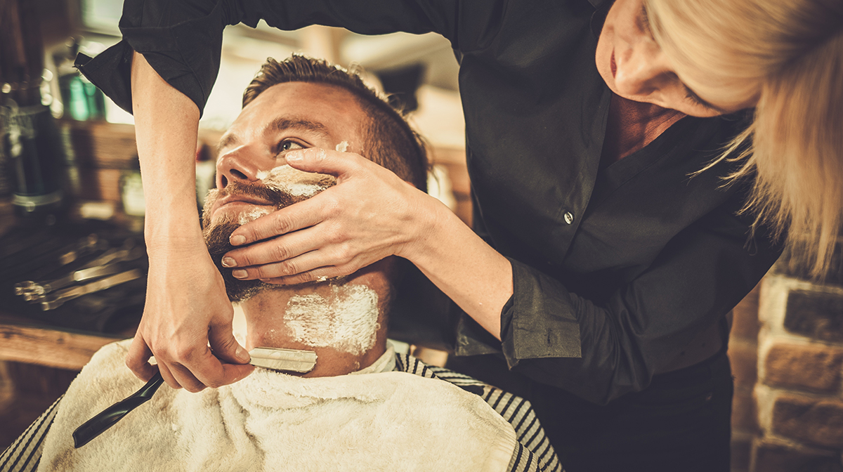 Man being shaved with cut throat razor