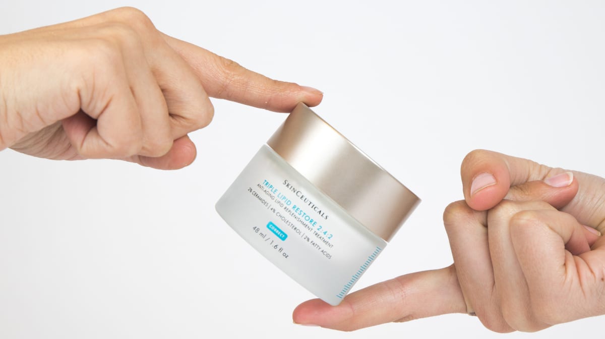 Two hands holding Skinceuticals cream