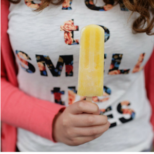 close up of lady holding yellow ice lolly