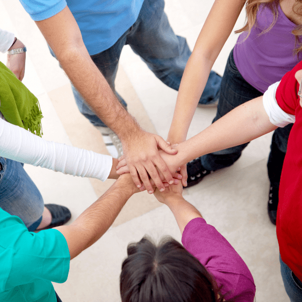 Friends putting hands into circle