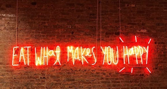 Eine Wandlampe aus Buschstaben, die sagt Eat What make you happy