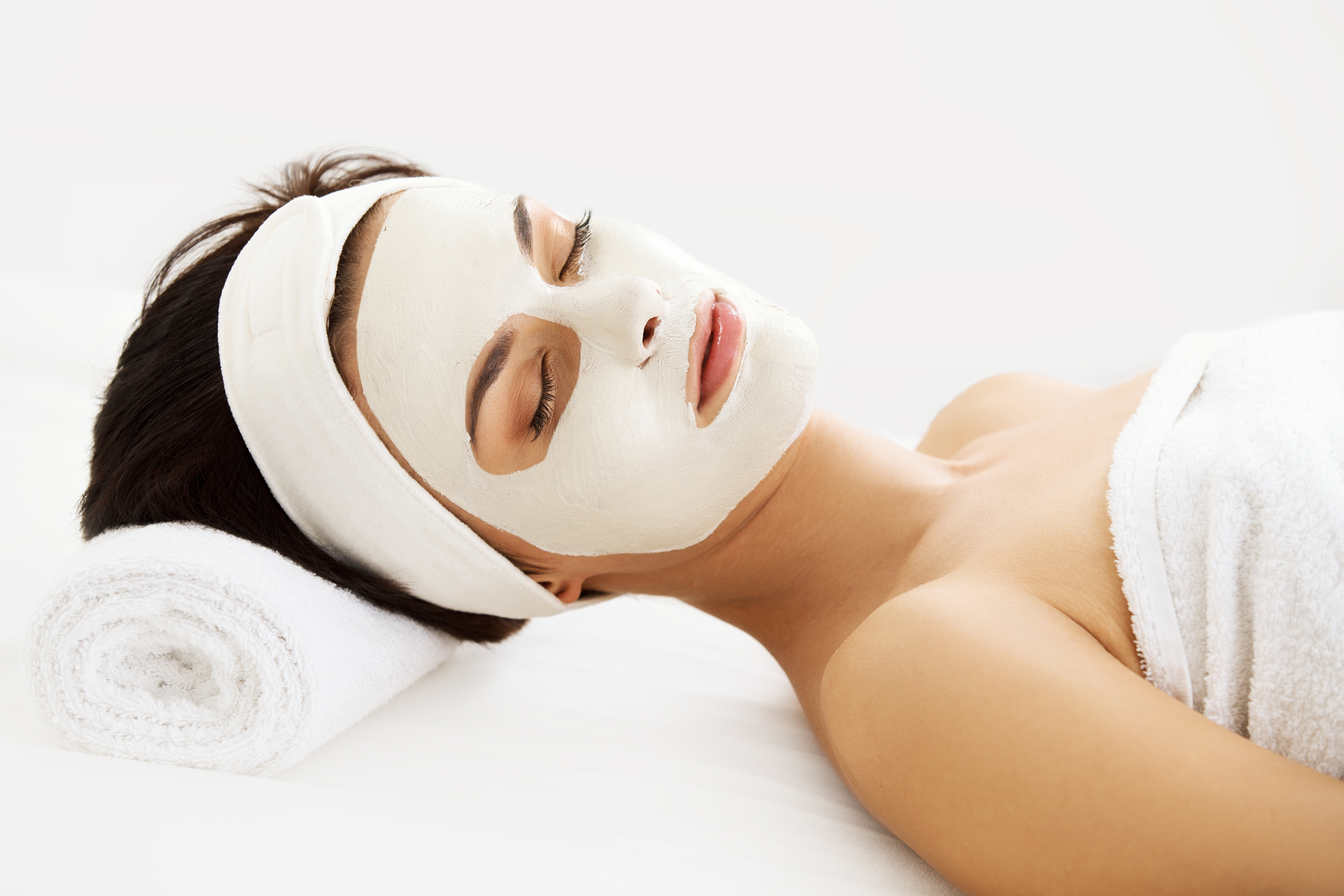 Cosmetic Mask. Beautiful Young Woman Getting a Beauty Treatment in Spa Salon. Isolated on White Backround