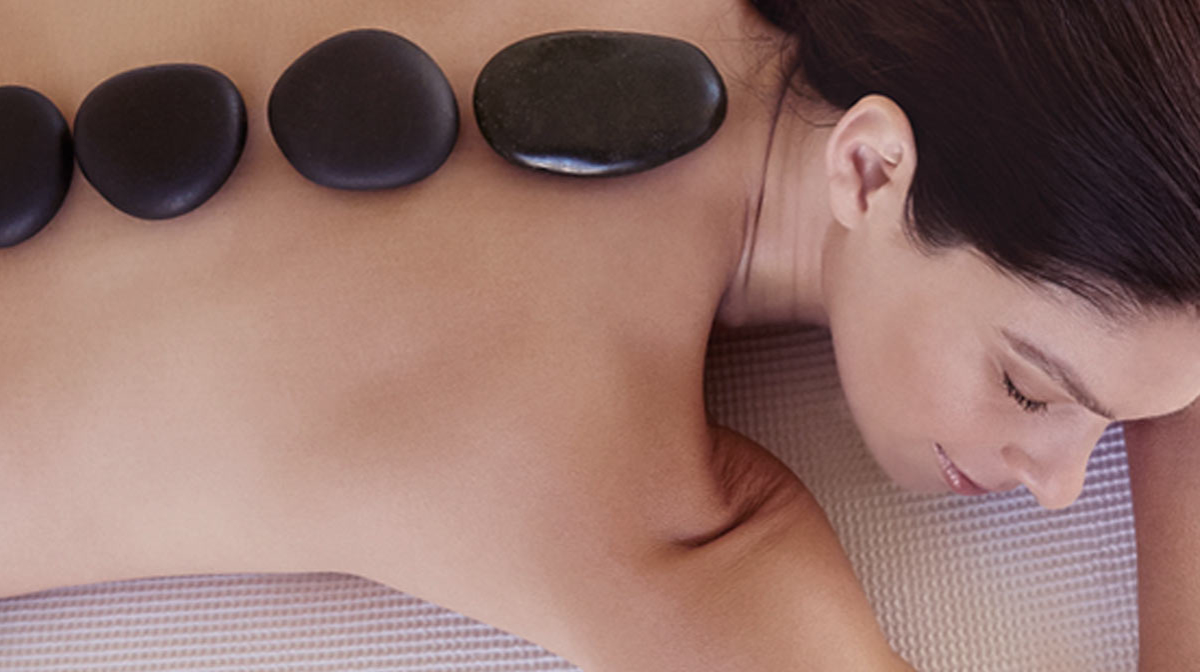 Hot stone massage treatment, woman with hot stones on her back
