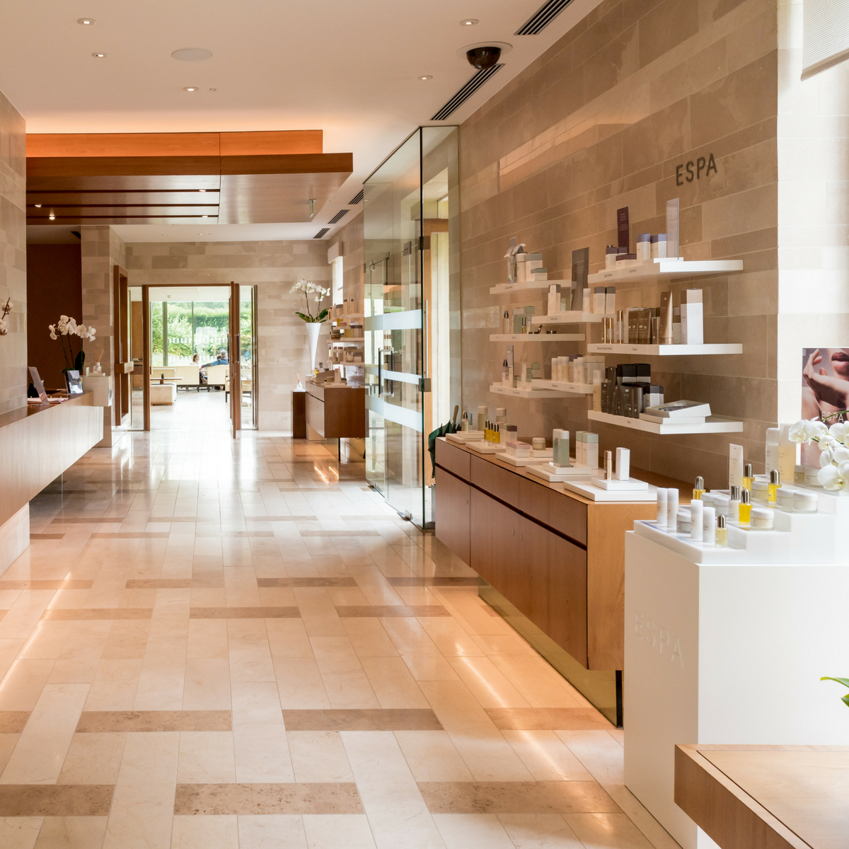 Pristine marble spa corridor with walls covered in products. 