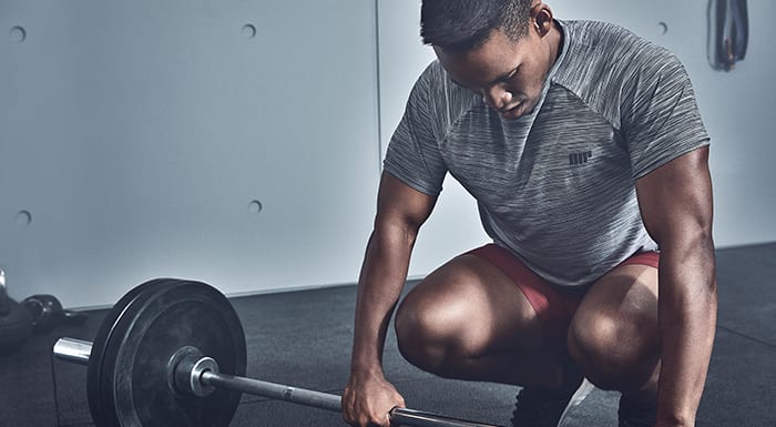 male athlete preparing to deadlift barbell