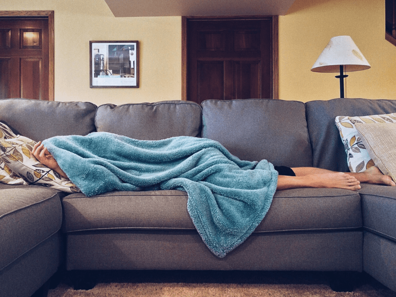 A woman lying on the couch sick