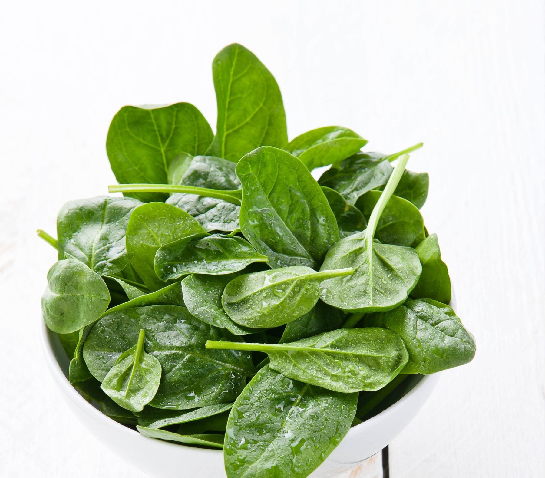 Young spinach in white bowl