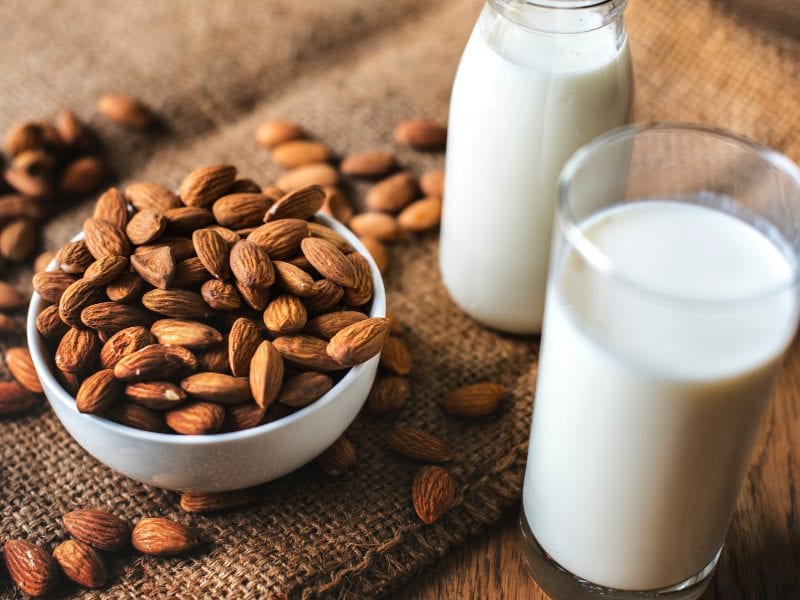 Some almonds and a glass of almond milk