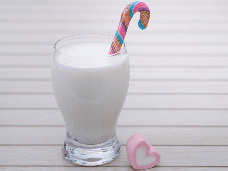 a glass of milk with a candy cane