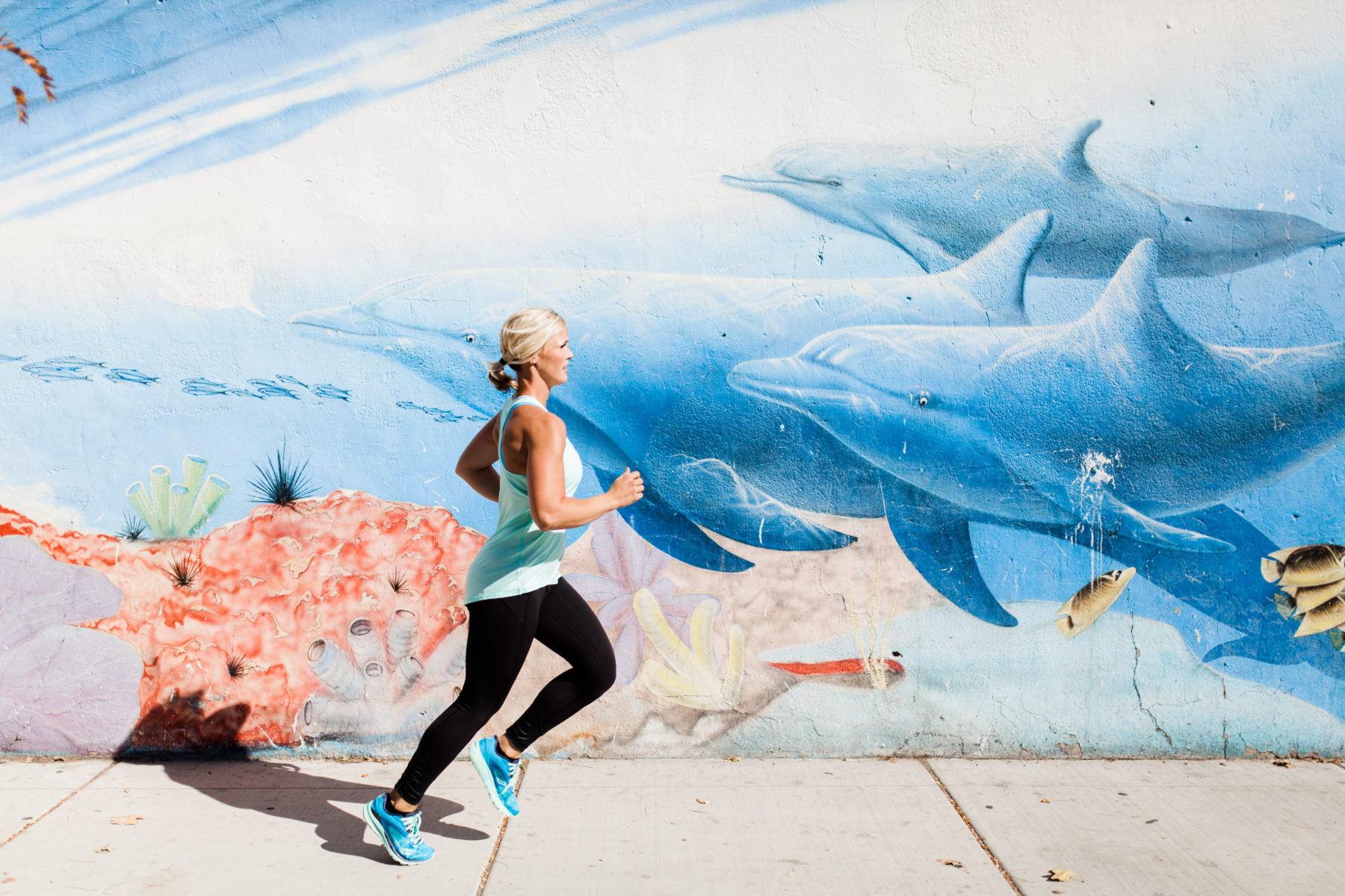 Woman running near a cool mural