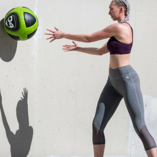 woman pumping out a glutamine fueled ball workout