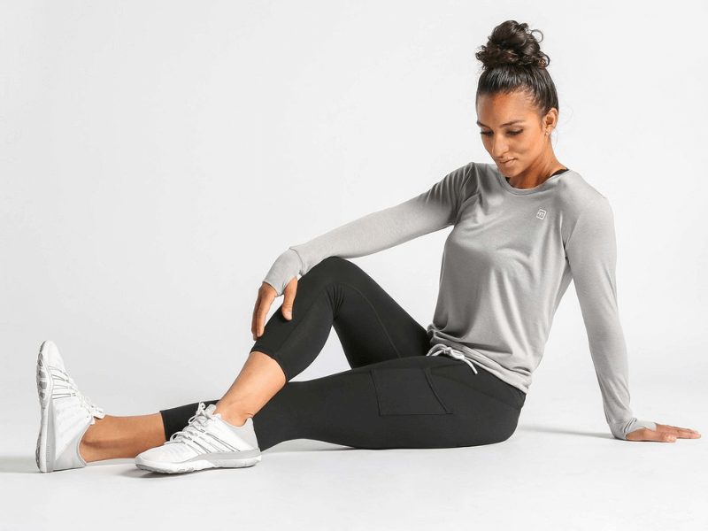 A woman wearing workout clothing and stretching