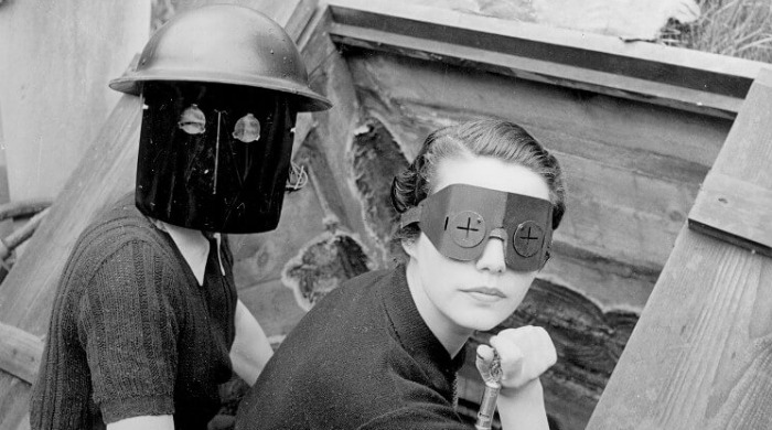 Lee Miller A Woman’s War: Two women whose faces are covered by protective helmets, masks and eyewear.
