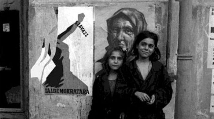Lee Miller A Woman's War: Two young girls stood in front of a wall with a propaganda poster on it.