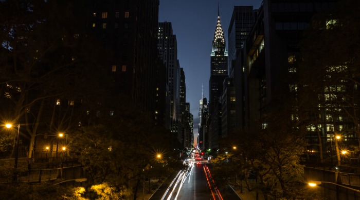 The Streets of New York City by Shaquel Munroe: A view down a street looking up to The Chrysler Building.