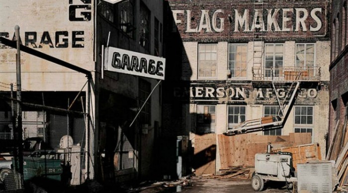 1970s San Francisco by Janet Delaney: An alleyway with "garage" signs, as well as a "flag makers" sign.