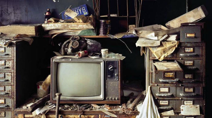 Ruins of Detroit Yves Marchand Romain Meffre: An old, dusty television surrounded by rusty shelves and rubbish.