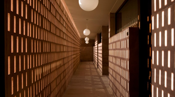 RAAS Jodphur: A view down a corridor with rectangular patterned gaps in one wall which is casting beautiful shadows on the other wall.