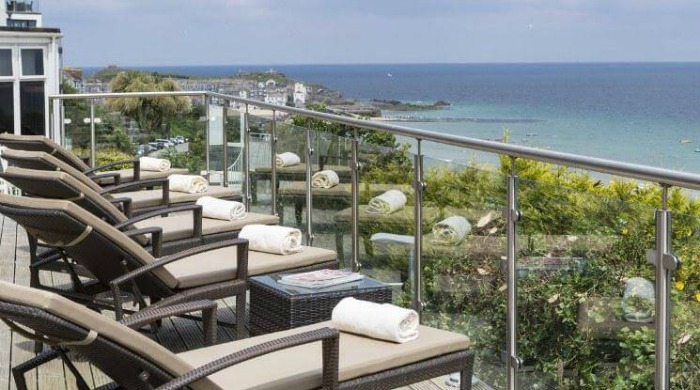 Five of the Best UK Spas: A balcony filled with deck chairs overlooking the sea at St Ives Harbour Hotel.