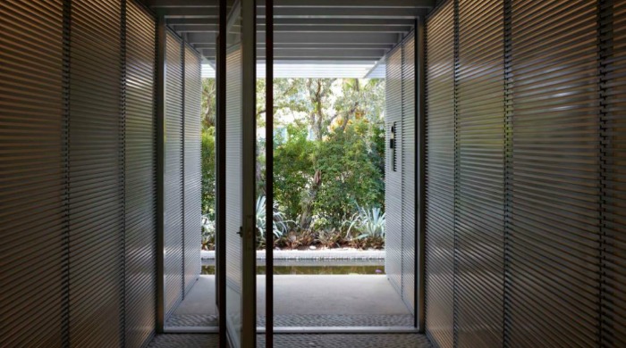 The view down a corridor leading outside from a minimal Miami beach house.