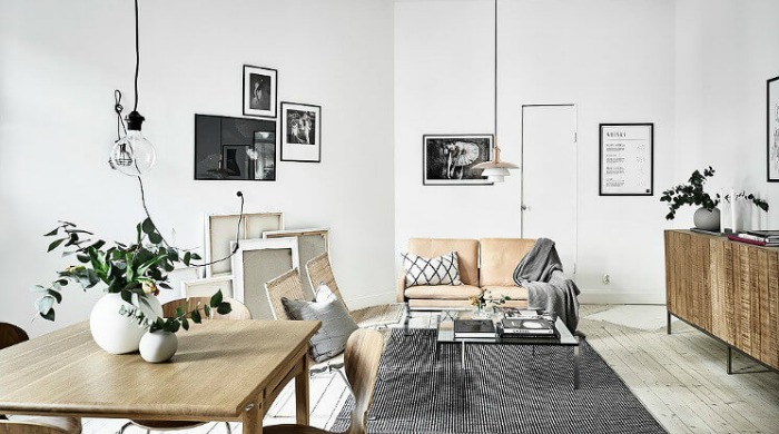A white living room incorporating black metal accents with black hanging lights and black picture frames.