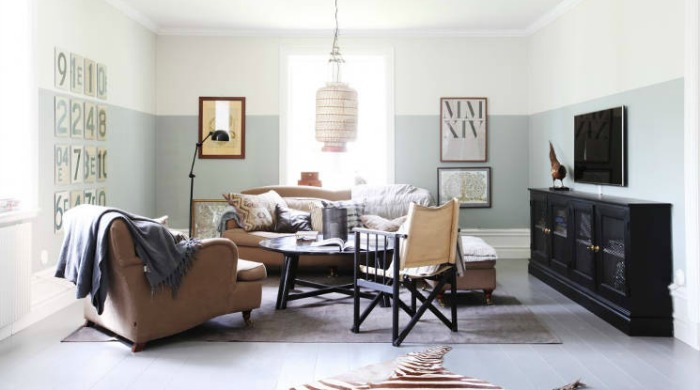 The living room in a Swedish country house with brown sofas, pastel coloured walls and a zebra rug on the floor.