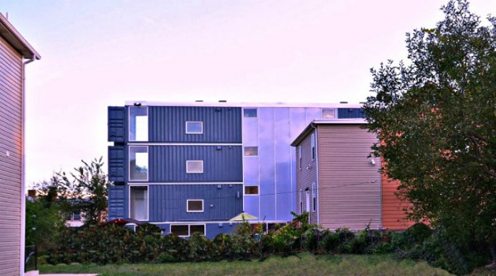 A side view of the shipping container apartments complex with four stories of shipping containers.