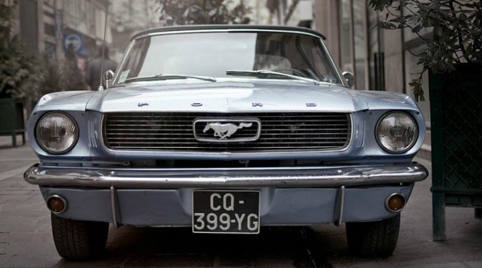 The front of a classic blue Mustang by Raphaël Année.