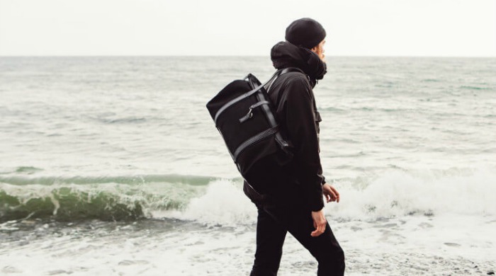 A male model carrying a Mismo bag.