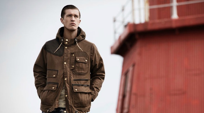 A male model wearing Barbour x White Mountaineering clothing.