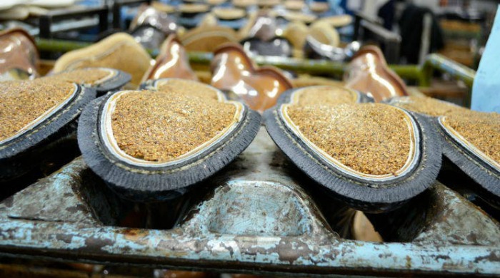 Cork being added to the bottoms of shoes at the Tricker's factory.