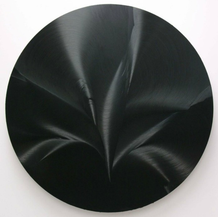 A black circular painting by Jason Martin.
