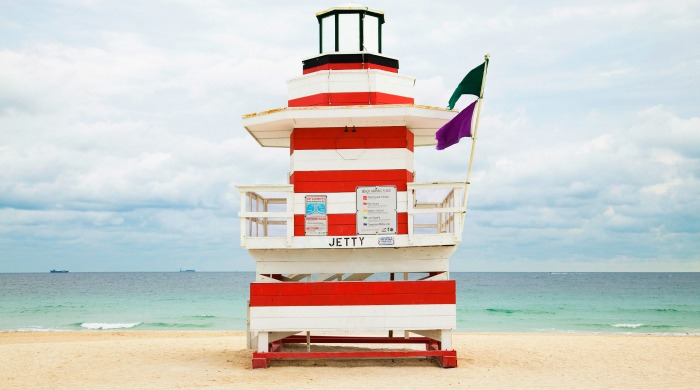 A red and white striped Miami beach lookout tower photographed by Léo Caillard.