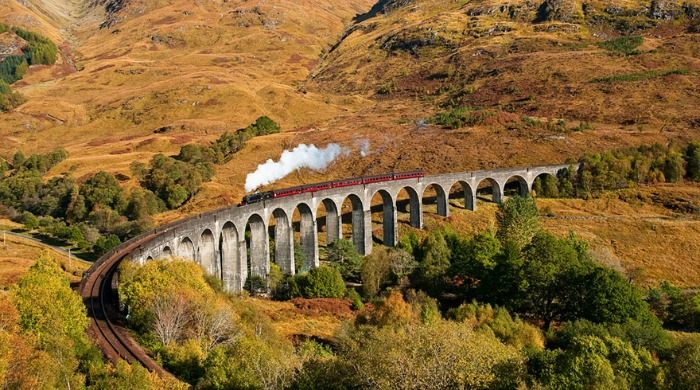 A train travelling through a valley in autumn by Andrew Sharland.