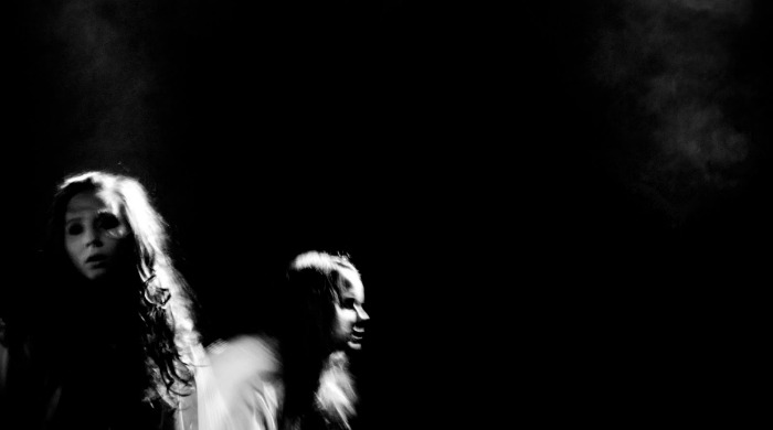 Two girls in dark shadows by Kjetil Karlsen.