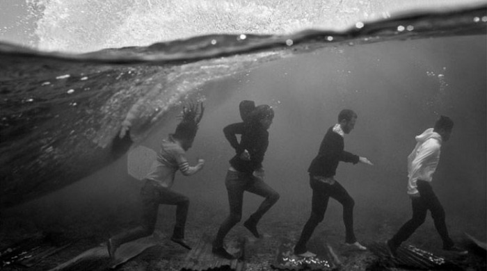 Four people walking across the sea floor from 'Dopamine' by Dustin Humphrey.