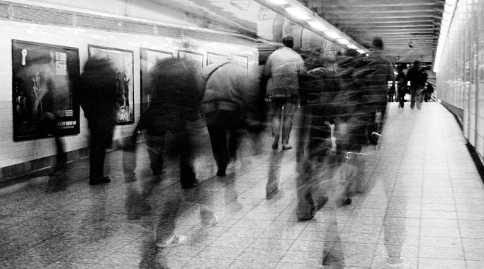 A crowd of commuters in an underground station by Viviana Peretti.